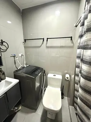 a bathroom with a white toilet and a sink at Comfy Makati Condo Wifi, Netflix and Disney in Manila