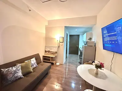 a living room with a couch and a table at Comfy Makati Condo Wifi, Netflix and Disney in Manila