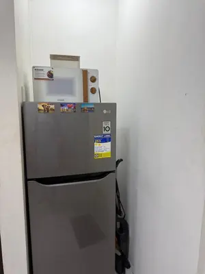 a refrigerator with a microwave on top of it at At Home in Santa Rosa in Santa Rosa