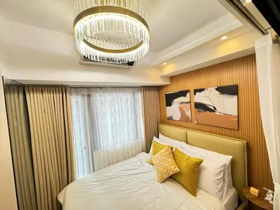 a bedroom with a bed and a chandelier at 1230 Flor Suite Shore 3 Residences near SM MOA by PrimeStay in Manila