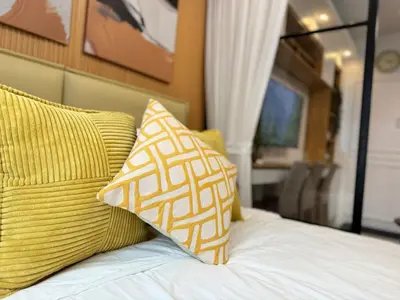 a bed with yellow and white pillows on it at 1230 Flor Suite Shore 3 Residences near SM MOA by PrimeStay in Manila