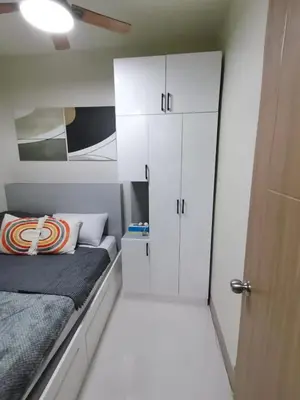 a small bedroom with a bed and white cabinets at Yammy's HomeyStyle Condo at Tower 3 Shore 3 Residences in Manila