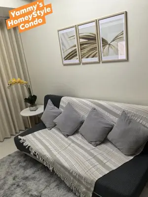 a bedroom with a bed with pillows and a window at Yammy's HomeyStyle Condo at Tower 3 Shore 3 Residences in Manila