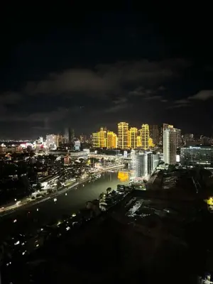 a city at night with a river and buildings at Eve's Den in Manila