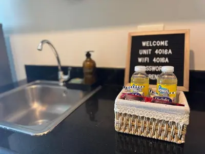 a kitchen counter with a sink and two bottles of beer at Luxury in the Makati Skyline in Manila