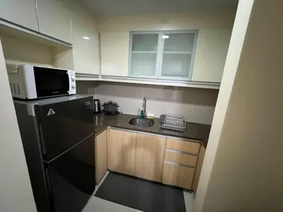 a small kitchen with a sink and a microwave at Wanderlust Haven in Manila