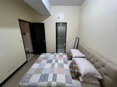 a bedroom with a bed with a quilt on it at Wanderlust Haven in Manila
