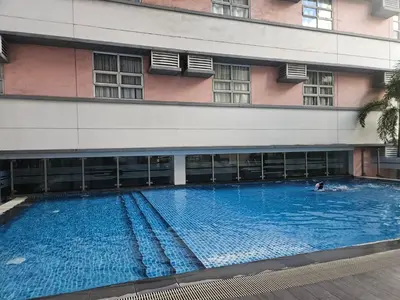 a large swimming pool in front of a building at Wanderlust Haven in Manila