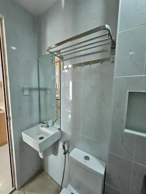a bathroom with a sink and a toilet and a mirror at Stunning 2 Bedroom near Airport in Manila