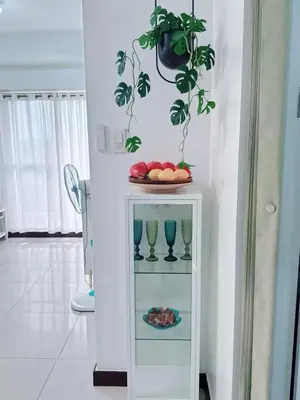 a white cabinet with a plate of fruit and a plant at Near NAIA 3 Condo in Manila