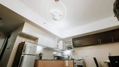 a kitchen with a refrigerator and a light on the ceiling at Venice Stay! Free Amenities, Steps to Grand Canal in Manila