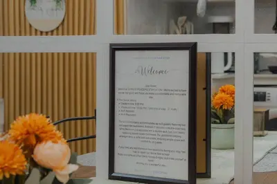 a menu in a frame on a table with flowers at Family Friendly Stay UrbanDeca in Manila