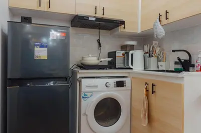 a kitchen with a washing machine and a washer at Family Friendly Stay UrbanDeca in Manila