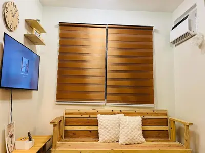 a large wooden screen in a living room with two pillows at Fablo Staycation By Enchanted Kingdom in Santa Rosa