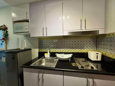a kitchen with a sink and white cabinets at Cassa Bella in Manila