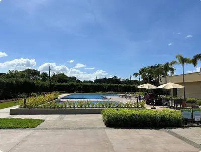 a swimming pool with tables and umbrellas in a resort at Tulip Garden Apricot Southwoods Binan 1BR with Pool & gym in Biñan