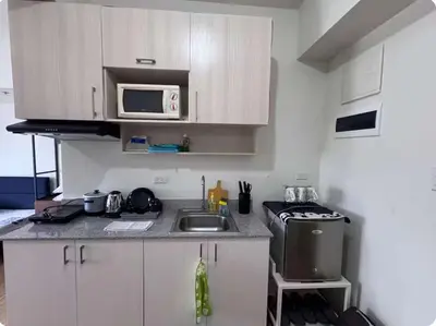 a small kitchen with a sink and a microwave at Tulip Garden Apricot Southwoods Binan 1BR with Pool & gym in Biñan