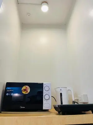 a microwave sitting on a counter next to a coffee maker at Fablo Getaway Staycation Beside Enchanted Kingdom in Santa Rosa