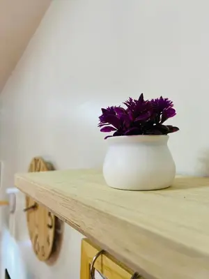 a white vase with purple flowers sitting on a counter at Fablo Getaway Staycation Beside Enchanted Kingdom in Santa Rosa