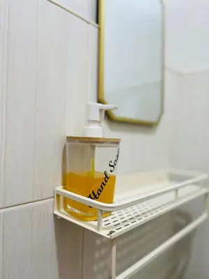 a bottle of oil sitting on a shelf in a bathroom at Fablo Getaway Staycation Beside Enchanted Kingdom in Santa Rosa