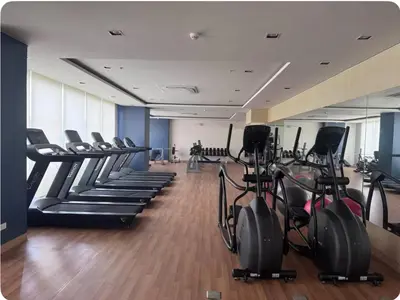 a gym with rows of treadmills and elliptical machines at Tulip Garden Apricot Bldg 1BR with pool and Gym in Biñan