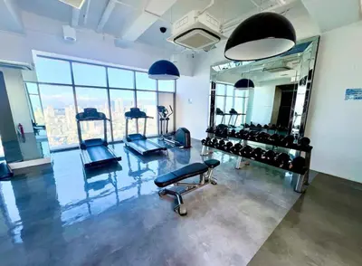 a fitness room with a mirror and some equipment at Acqua Private Residences -IGUAZU Tower 16th flr - Mandaluyong in Manila