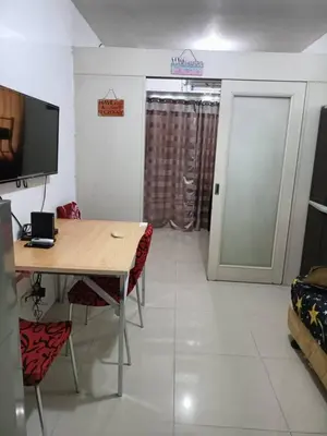 a room with a table and chairs and a television at My Place in Manila