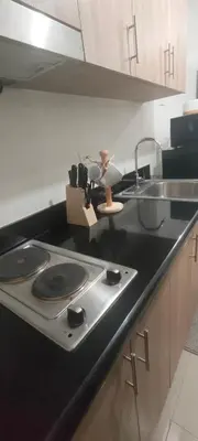 a kitchen counter with a stove and a sink at Sweet Staycation in Manila