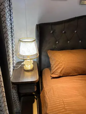 a lamp on a table next to a bed at Modern Studio near LRT, MOA & Star City in Pasay in Manila