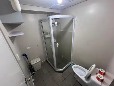 a small bathroom with a shower and a toilet at Rolly's Place in Manila