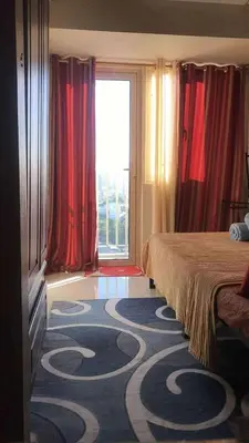 a hotel room with a bed and a large carpet at LJ's escape 2BR COAST Residences in Manila