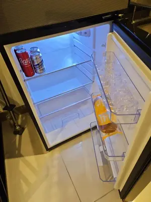 an open refrigerator with drinks and bottles of soda at Condo next door in Manila