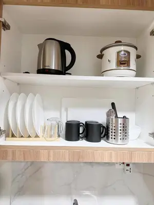 a shelf with cups and utensils in a kitchen at 212 Budget Condo at Shore 3 The Dwelling place in Manila