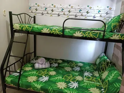 a bedroom with two bunk beds with a green blanket at Roiden Sea Residences in Manila