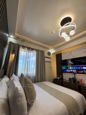 a bedroom with a large bed with a large television at The Crystal Cove Cabin in Puting Kahoy