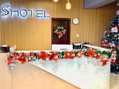 a long counter with red flowers and a christmas tree at Hotel S in Manila