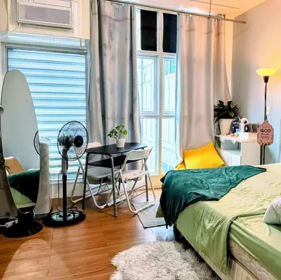 a bedroom with a bed and a table and a window at StudioUnit Near Airport up to 3pax WiFi in Manila