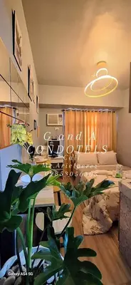 a living room with a plant in the middle of a room at G and A CONDOTELS in Manila