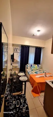 a bedroom with two beds and a table in it at G and A CONDOTELS in Manila