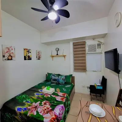 a bedroom with a bed and a ceiling fan at G and A CONDOTELS in Manila