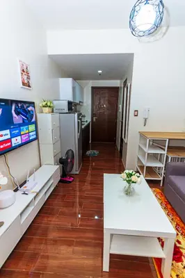 a living room with a white table and a kitchen at Air Residence Penthouse 59 Suite Gym Swim Park 300 mbps in Manila
