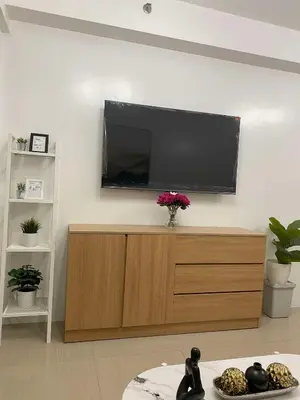 a living room with a flat screen tv on a wall at Spacious 2BR Suites at MOA in Manila