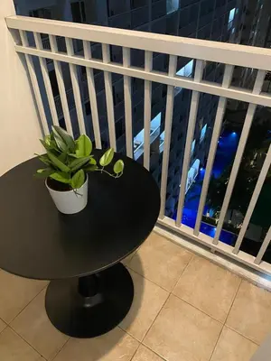 a black table with a potted plant on a balcony at Spacious 2BR Suites at MOA in Manila