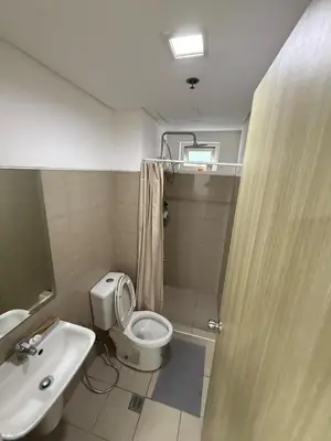 a bathroom with a toilet and a sink and a shower at Spacious 2BR Suites at MOA in Manila
