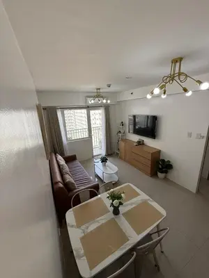 a living room with a table and a couch at Spacious 2BR Suites at MOA in Manila