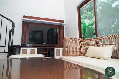a living room with a glass table and a tv at Asana Amadeo a private villa near Tagaytay in Amadeo