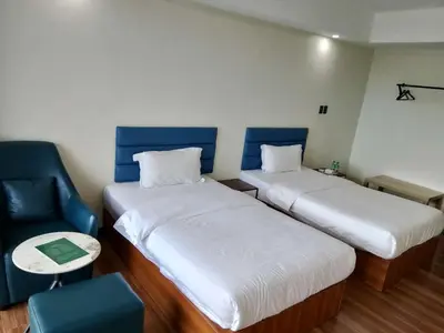 a small room with two beds and a chair at Hotel S Casiana Residences in Manila