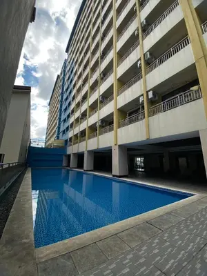 a large building with a swimming pool in front of it at Hotel S Casiana Residences in Manila