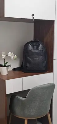 a bag sitting on top of a desk with a chair at 2 Bedroom Mall of Asia and Airport in Manila