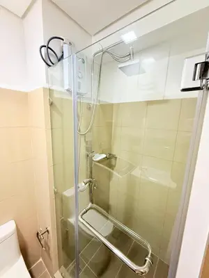 a shower with a glass door in a bathroom at Nestled Haven in Manila